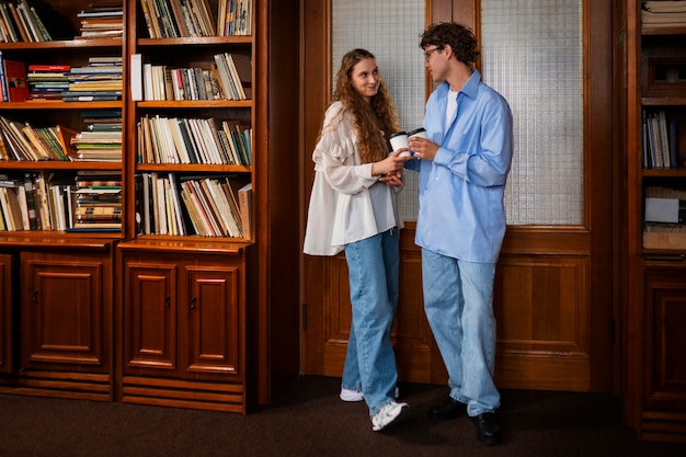 Pareja de tiro medio teniendo una cita en la librería