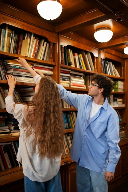 Pareja de tiro medio teniendo una cita en la librería