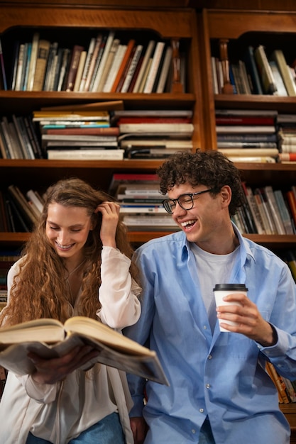 Pareja de tiro medio teniendo una cita en la librería