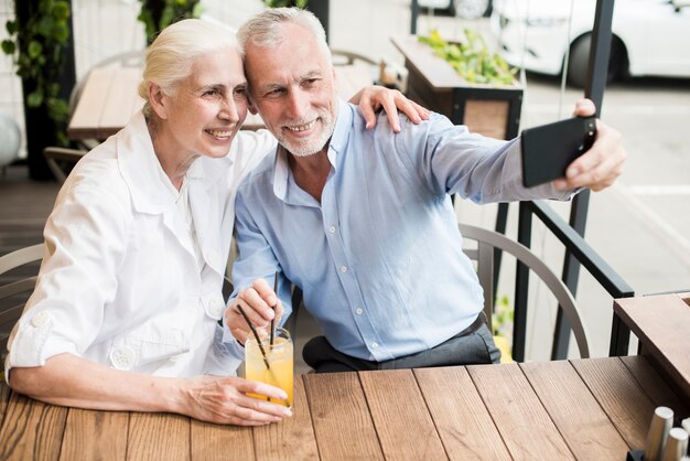 Pareja de tiro medio tomando un selfie