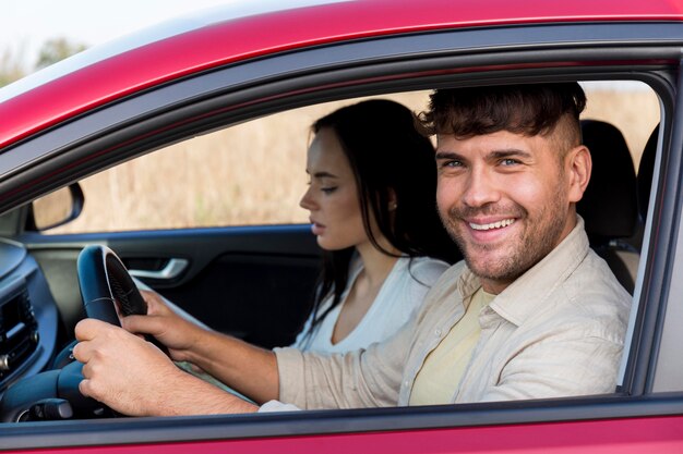 Pareja de tiro medio viajando en coche