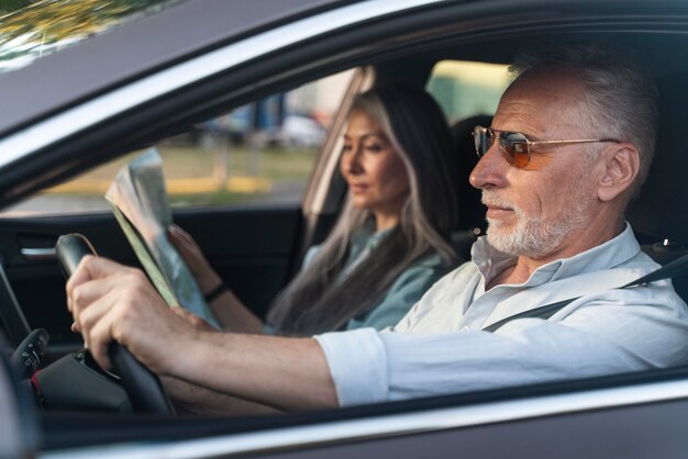 Pareja de tiro medio viajando en coche