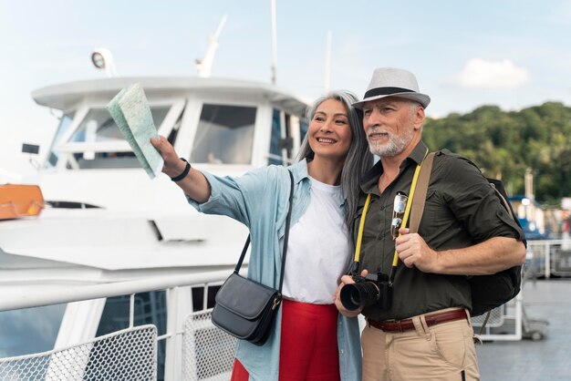 Pareja de tiro medio viajando junto con mapa