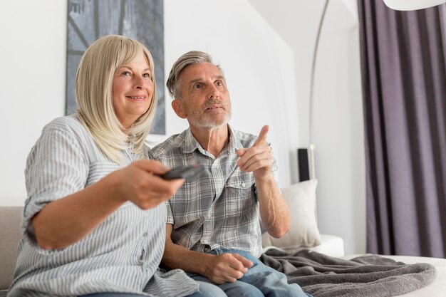 Pareja de tiro medio viendo la televisión