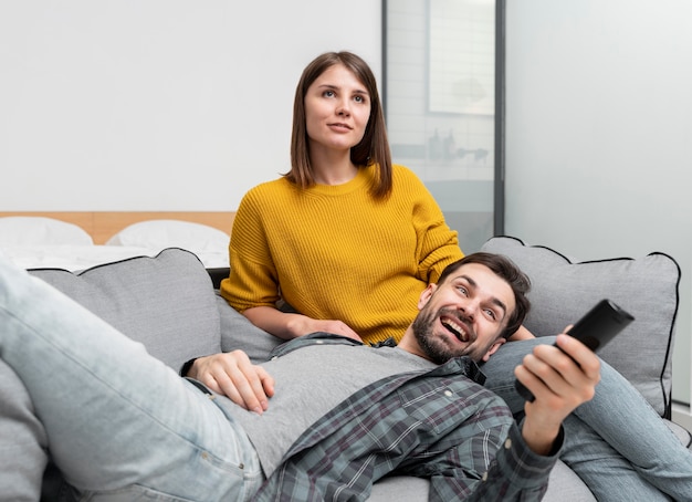 Pareja de tiro medio viendo la televisión