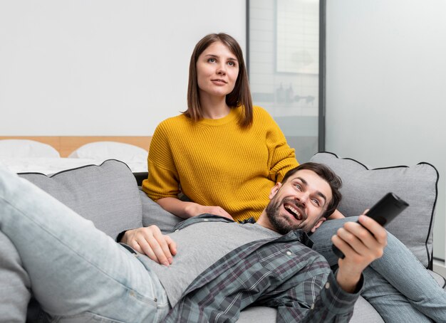 Pareja de tiro medio viendo la televisión