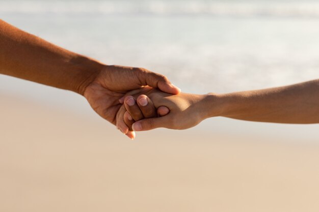 Pareja tomados de la mano en la playa