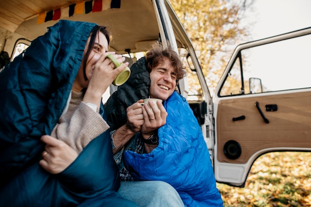 Pareja tomando café desde su camioneta