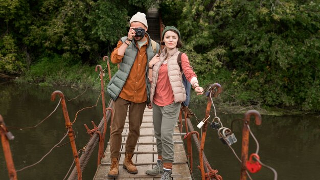 Pareja tomando fotos en el puente de madera