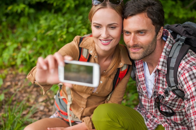 Pareja tomando selfie en el bosque