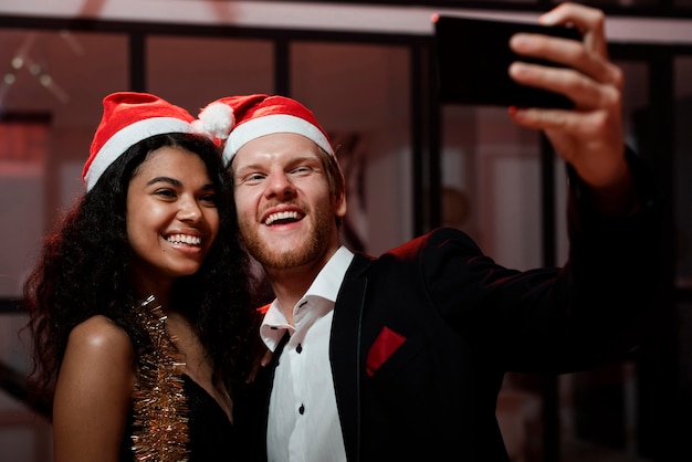 Foto gratuita pareja tomando un selfie en la fiesta de fin de año