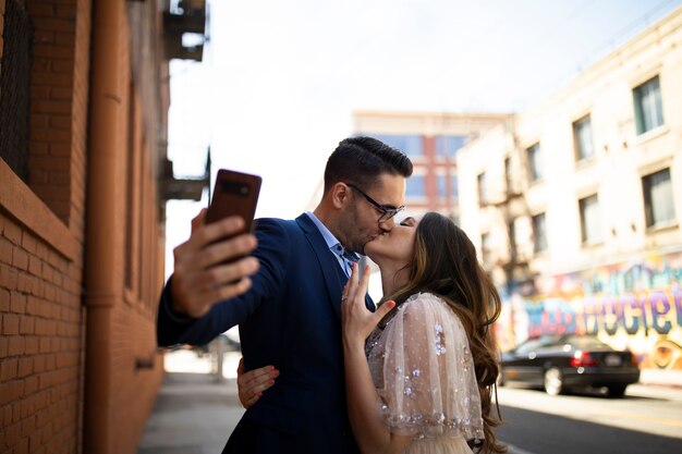 Pareja tomando selfie juntos al aire libre con anillo de compromiso