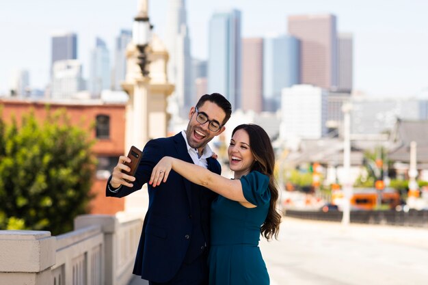 Pareja tomando selfie juntos al aire libre con anillo de compromiso