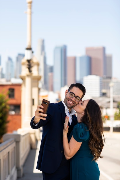 Pareja tomando selfie juntos al aire libre con anillo de compromiso