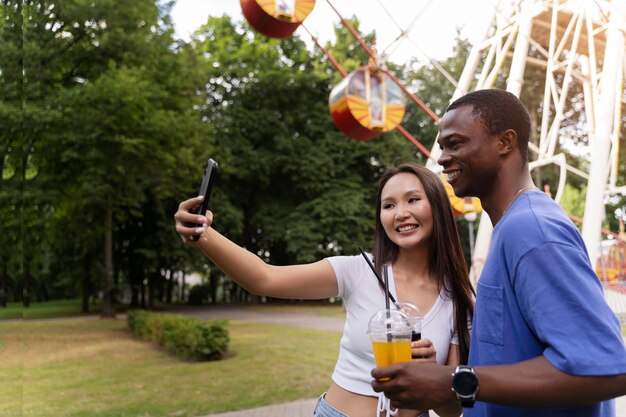 Pareja tomando selfie mientras están juntos en la rueda de la fortuna