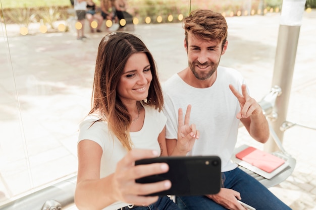 Pareja tomando una selfie y mostrando el signo de paz