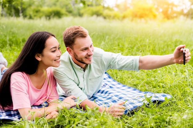 Pareja tomando selfie en picnic