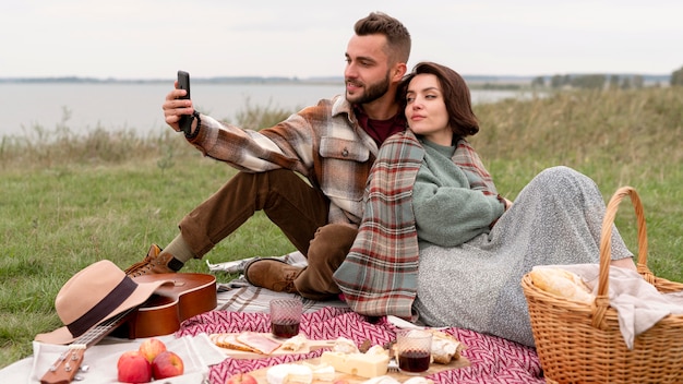 Pareja tomando selfie en picnic