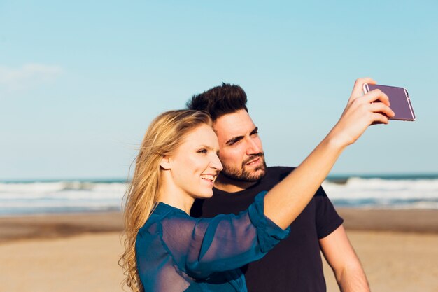 Pareja tomando selfie en la playa