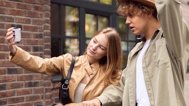 Pareja tomando selfie con scooters fuera