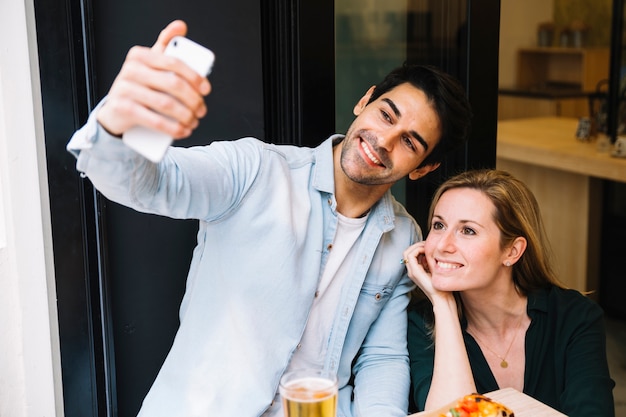 Foto gratuita pareja tomando selfie en smartphone