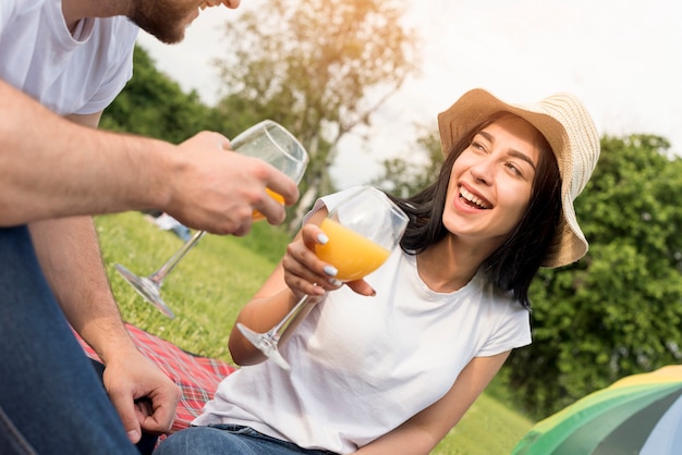 Pareja tomando zumo de naranja en manta de picnic