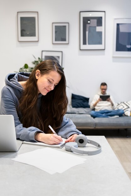 Pareja trabajando desde casa juntos en el sofá