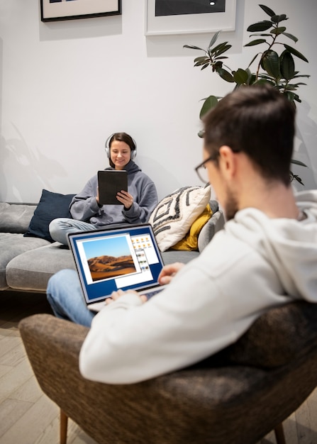 Pareja trabajando juntos desde casa en dispositivos