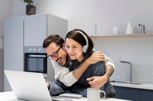 Pareja trabajando juntos desde la cocina de casa