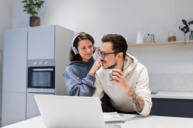 Pareja trabajando juntos desde la cocina de casa