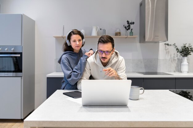 Pareja trabajando juntos desde la cocina de casa