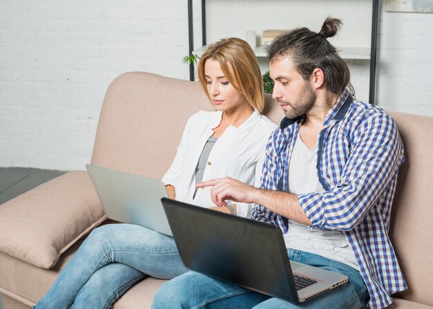 Foto gratuita pareja trabajando con portátiles