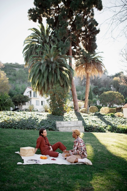 Pareja trans hablando mientras hace un picnic en el parque