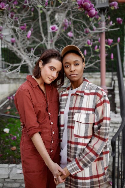 Pareja trans posando y tomados de la mano en las calles de la ciudad