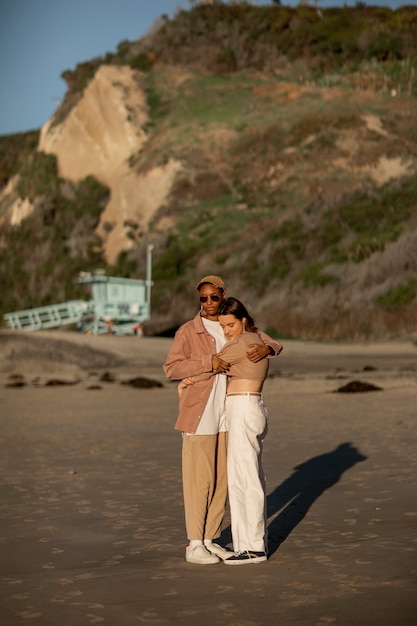 Pareja trans siendo cariñosa y abrazándose en la playa