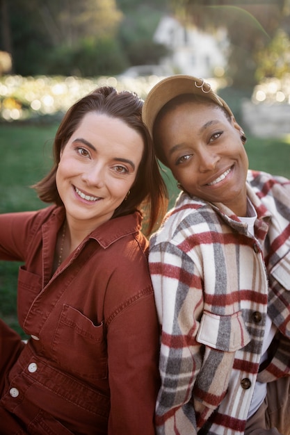 Pareja trans siendo feliz y sonriendo mientras hace un picnic en el parque