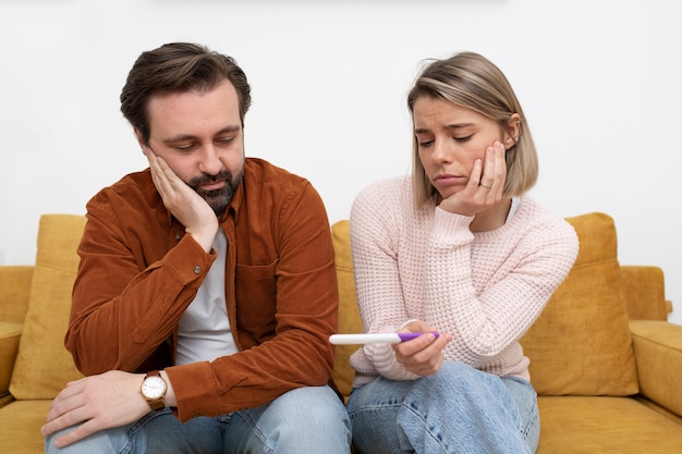 Pareja triste de tiro medio en casa