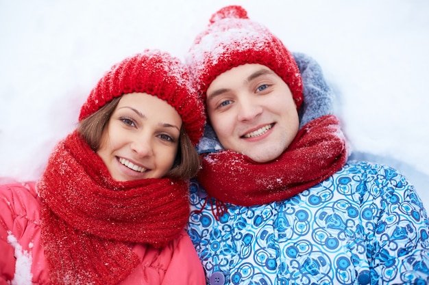 Pareja tumbada en la nieve