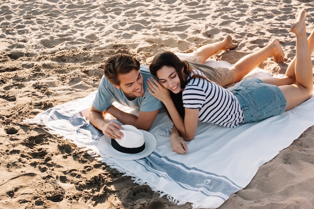 Foto gratuita pareja tumbada en la playa