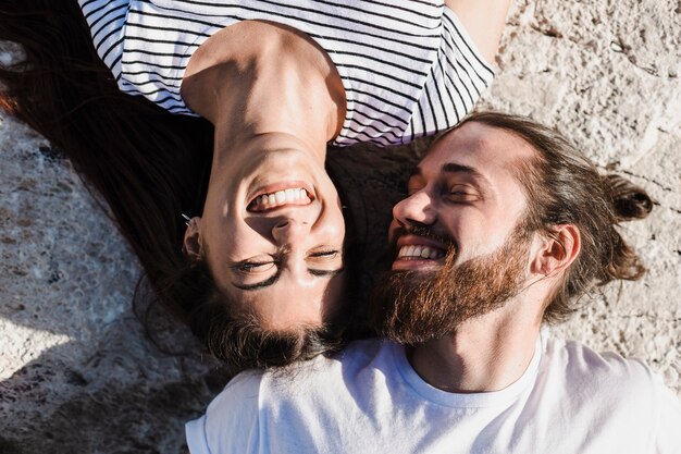 Pareja tumbada en rocas por el mar