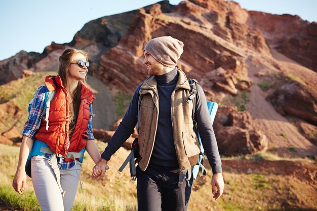 Pareja de turistas alegres tomando caminata