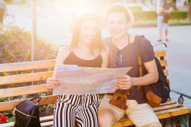 Pareja de turistas en banco con sol