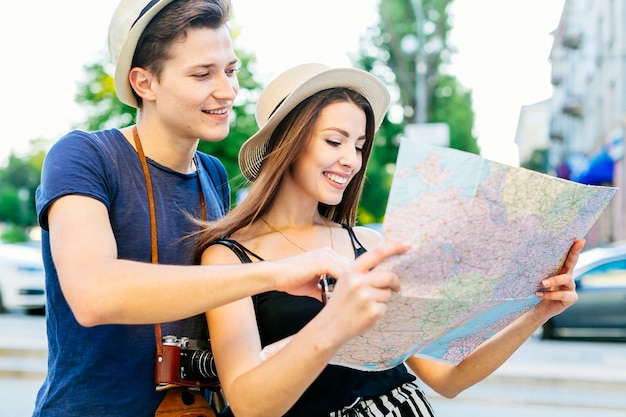 Pareja de turistas en ciudad mirando a mapa