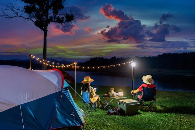 Pareja de turistas disfrutando de acampar junto al lago.