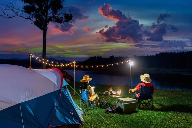 Pareja de turistas disfrutando de acampar junto al lago.