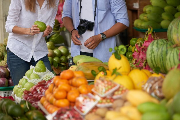 Pareja de turistas eligiendo frutas