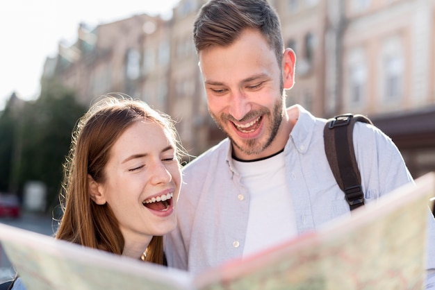 Pareja de turistas felices mirando el mapa