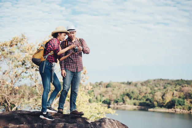 Pareja de turistas con fotografía en montaña.