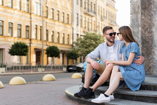 Pareja de turistas posando abrazos en pasos al aire libre