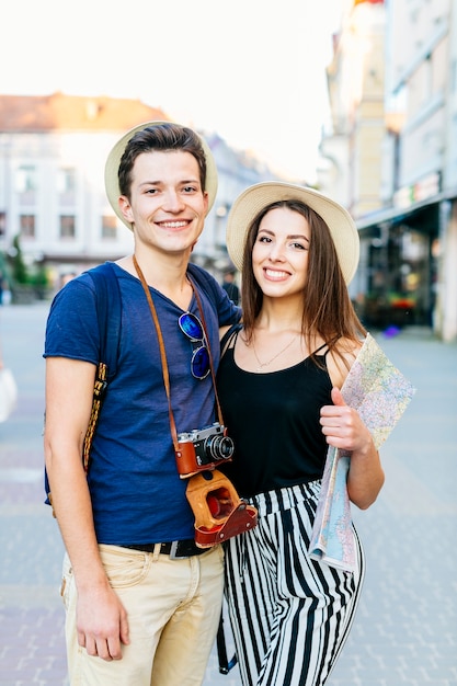 Pareja de turistas sonrientes en ciudad